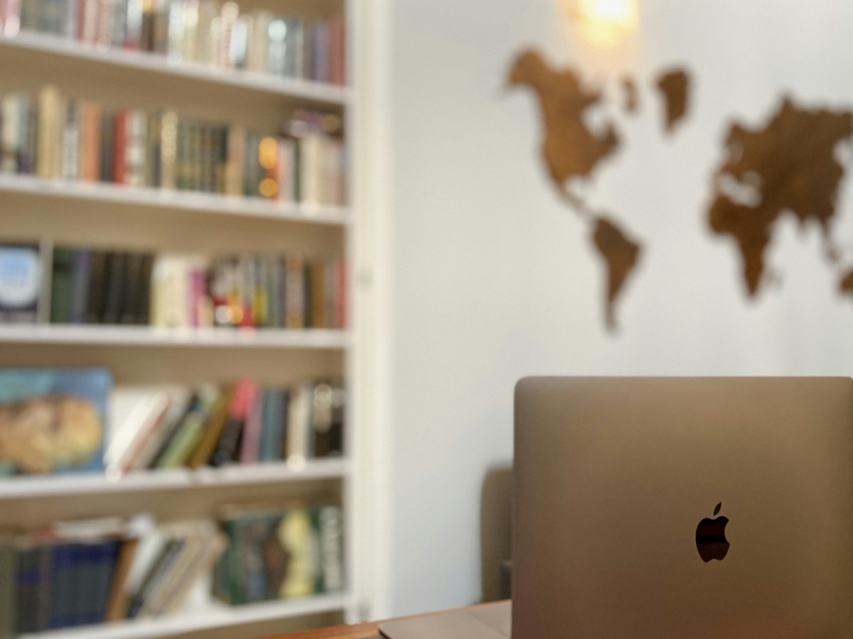 Laptop on a desk in front of a world map, ready to change the Windows display language
