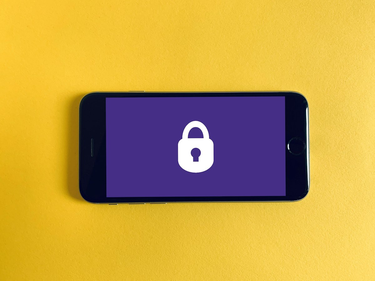 Smartphone next to a padlock, representing deleting saved Google passwords on Android or iPhone