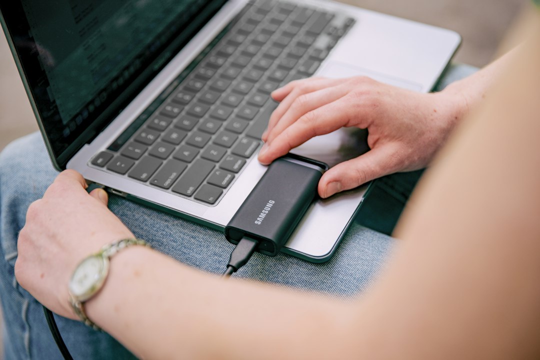 Person using a laptop and mouse to look through previous versions of a folder