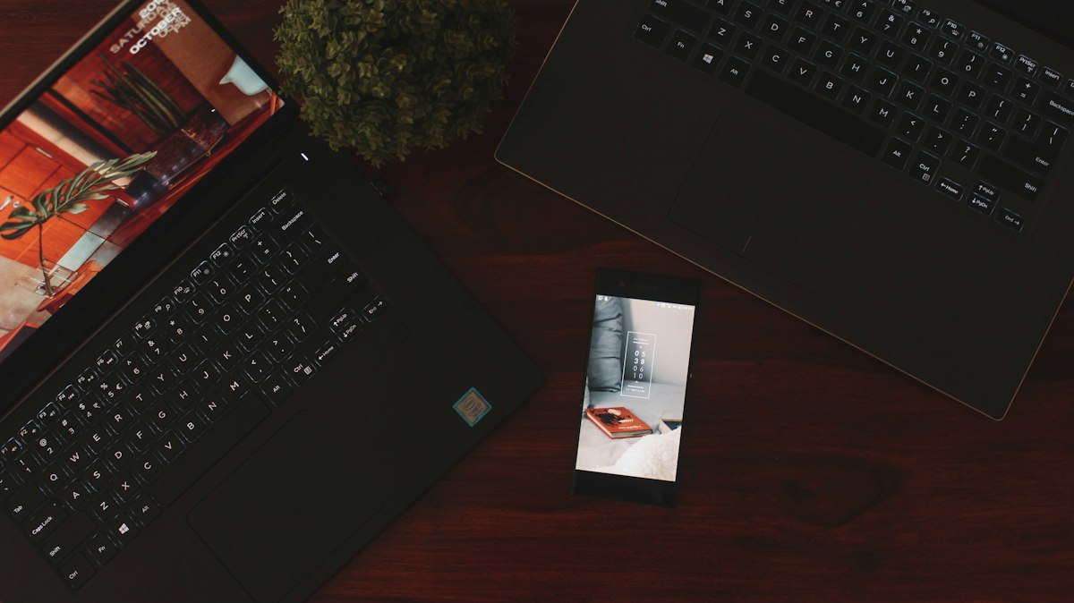 Person using a laptop and a phone together, where a synced device can bring deleted Google passwords back