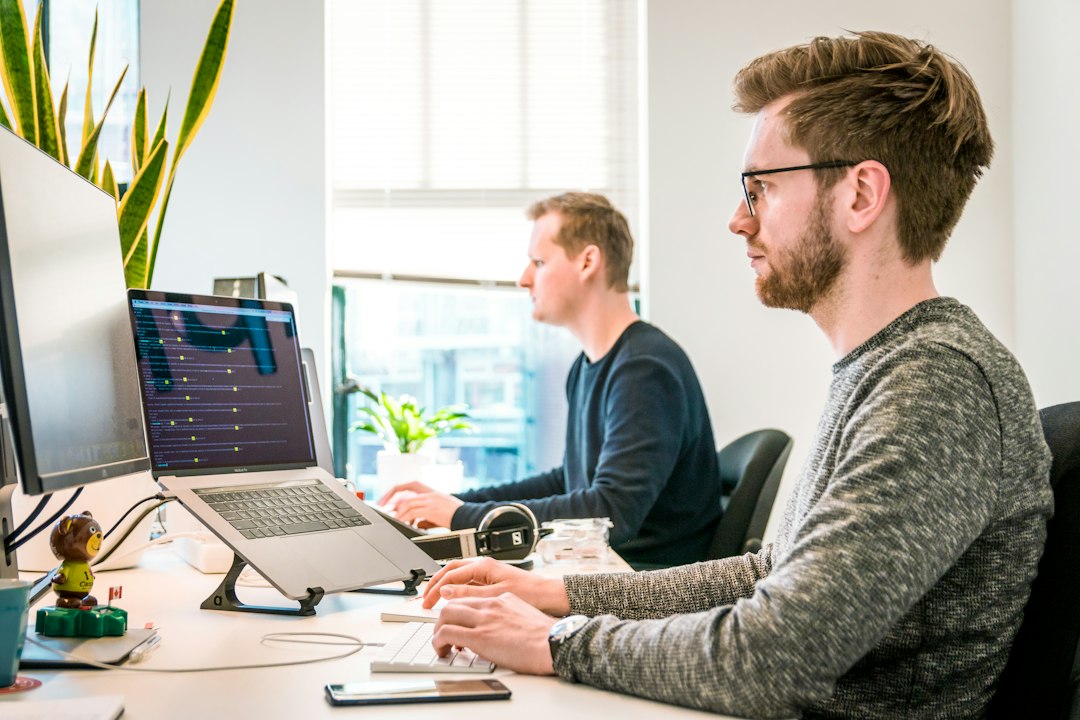 IT staff working at office computers, where admins use the Group Policy Management Console on Windows 11