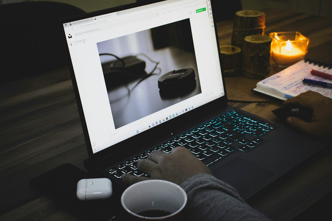 Hands on a laptop keyboard checking JPG quality and file size after converting from BMP