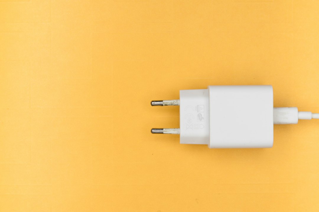 White power adapter ready to plug back in after resetting a laptop's battery driver