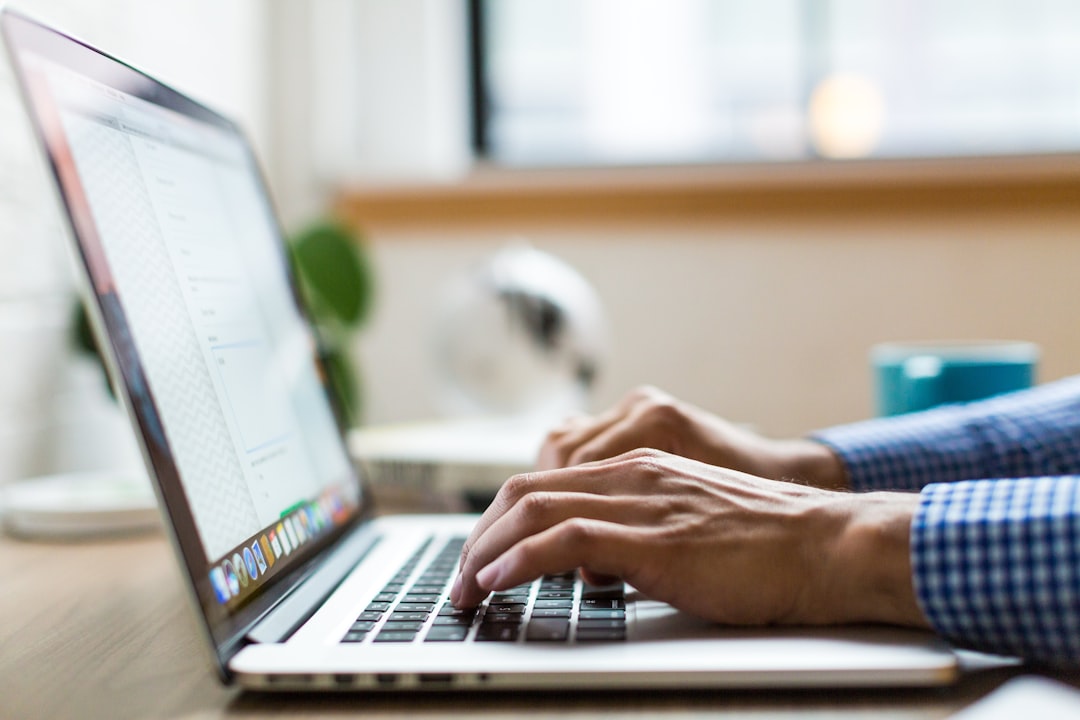 Hands typing on a laptop keyboard, representing Outlook keyboard shortcuts for replying, searching and filing email