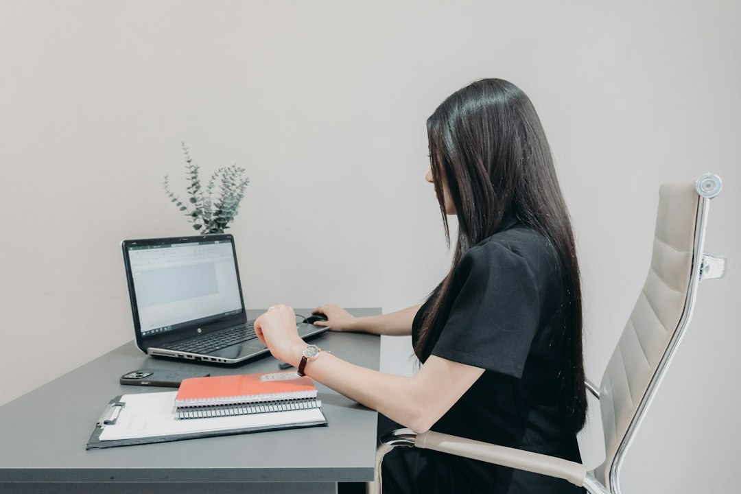 Person at a laptop with printed notes, turning a picture of a table into Excel data