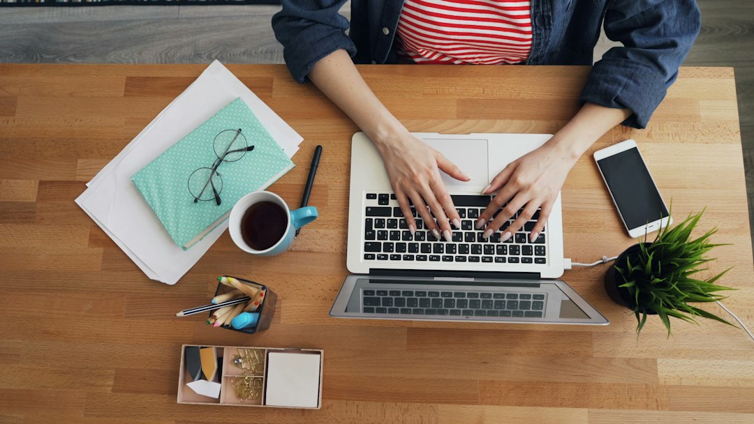Person working on a laptop at a wooden desk, repairing an Outlook data file