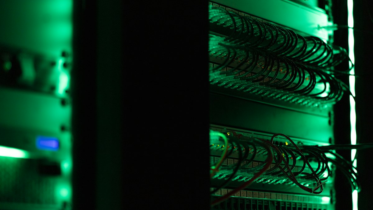 Server rack in a dark room, where a SQL Server database can get stuck in Recovery Pending after a restart