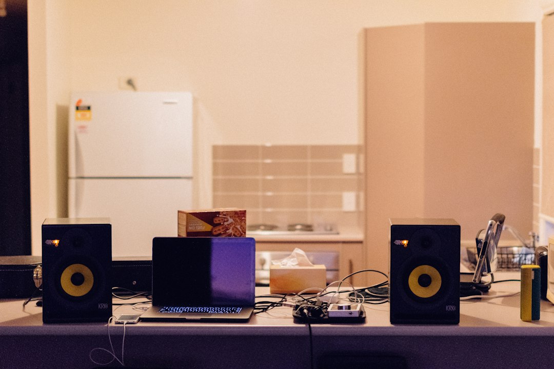 Speakers and a laptop on a table, representing recording computer audio with Stereo Mix in Windows