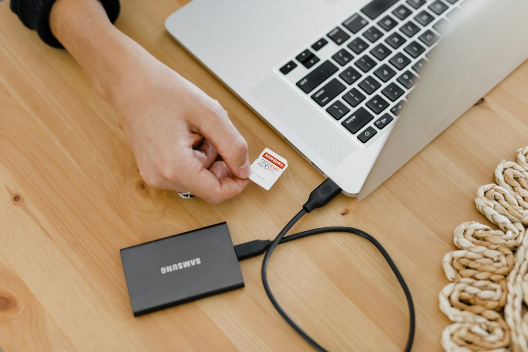Person holding an open laptop, the kind of PC that boots much faster after moving Windows to an SSD