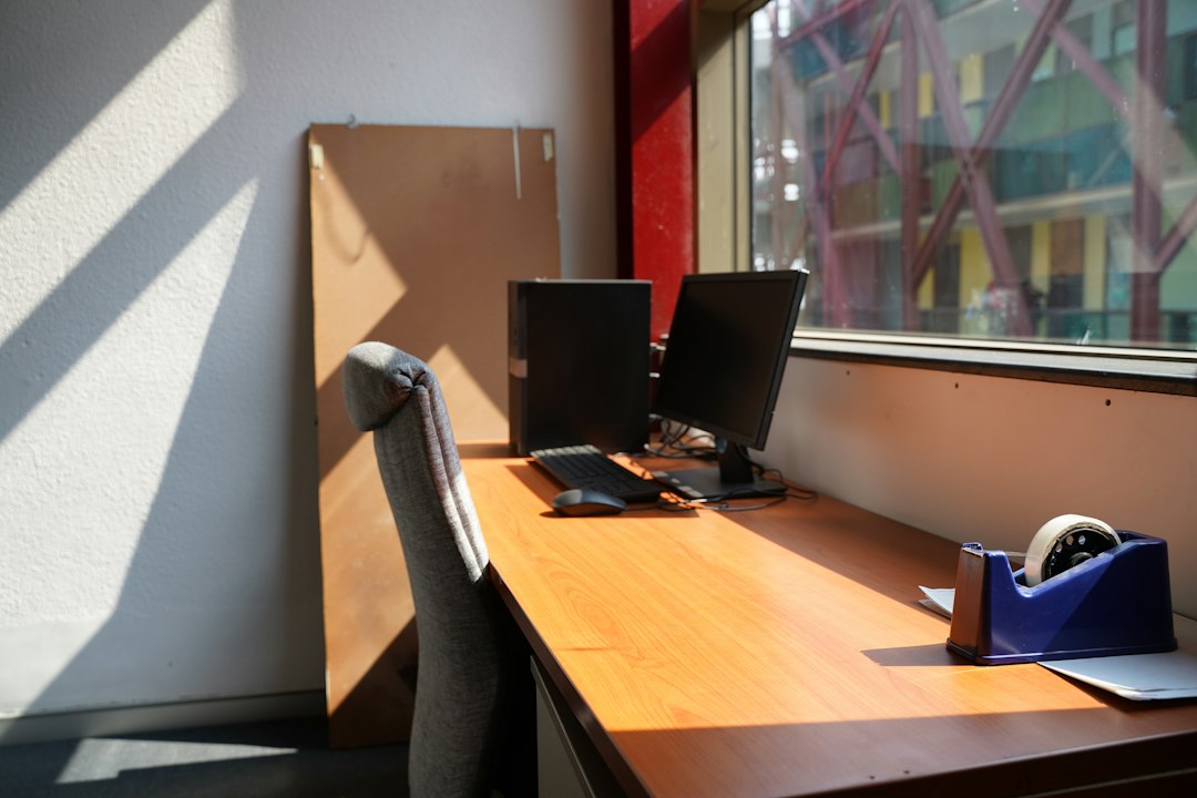 Laptop on a desk next to a window